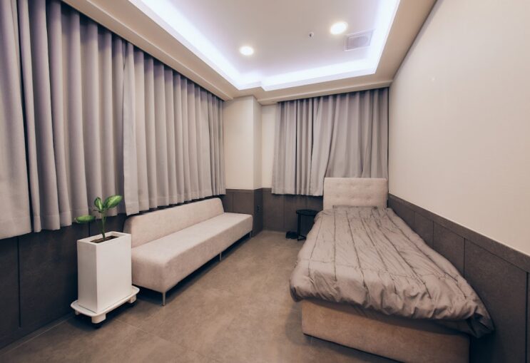 A private single-bed IV suite at Saeron Clinic with curtains and a sofa