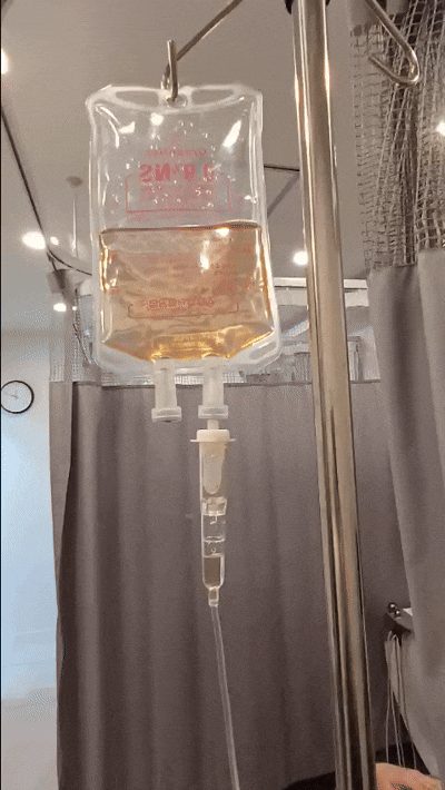 An IV bag and IV line being administered to a patient in a treatment room
