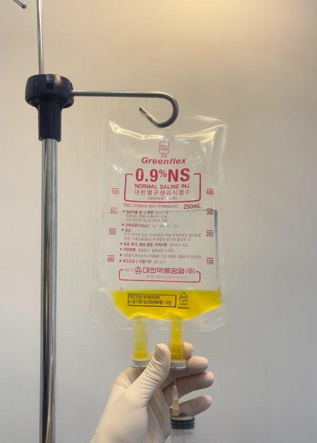 Medical staff preparing a yellow high-dose vitamin C drip
