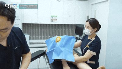 시술 준비를 마친 무릎에 소독포를 덮고 재생주사를 준비하는 장면
